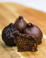 Load image into Gallery viewer, Dark chocolate covered figs cut in half.
